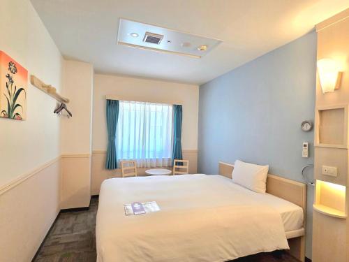 a hotel room with a bed and a window at Toyoko Inn Daegu Dongseongro in Daegu