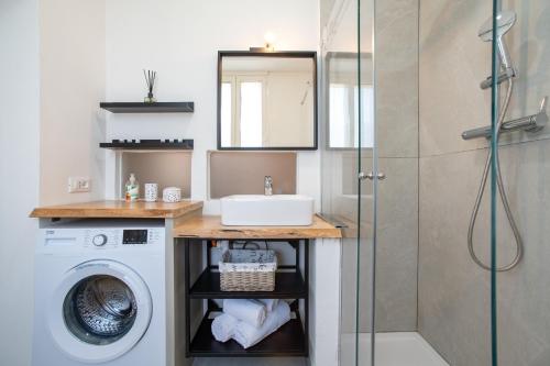 a bathroom with a sink and a washing machine at Emy House Charming Apt Stunning Views Balcony AC in Carate Urio