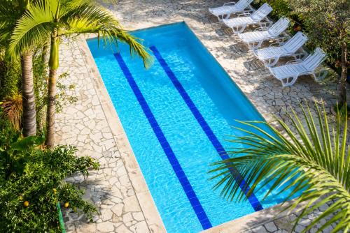 an overhead view of a swimming pool with chairs and palm trees at נופש דביר - צימרים מהממים למשפחות עם ג'קוזי ובריכה ליד הכנרת in Migdal