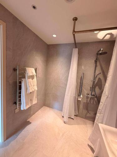 a bathroom with a shower and a shower curtain at Cobo Bay Hotel in Castel
