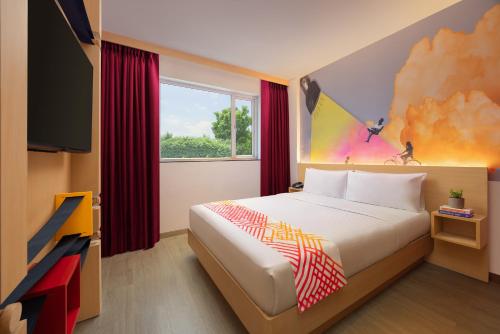 a bedroom with a bed and a large window at Ginger Pantnagar in Pantnagar