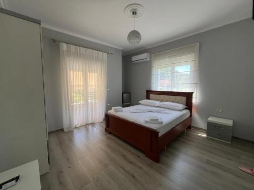 a bedroom with a bed and a wooden floor at Vila Gregor in Tushemisht