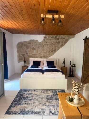 a bedroom with a white bed and a wooden ceiling at Mlýn Slavonice in Slavonice