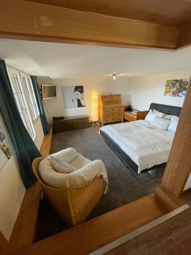 a bedroom with a bed and a chair in a room at Niesenblick in Aeschlen