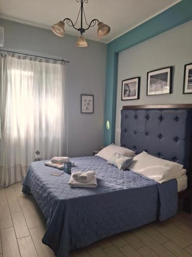 a bedroom with a blue bed with towels on it at BebNonnaMaria1928 in Salerno