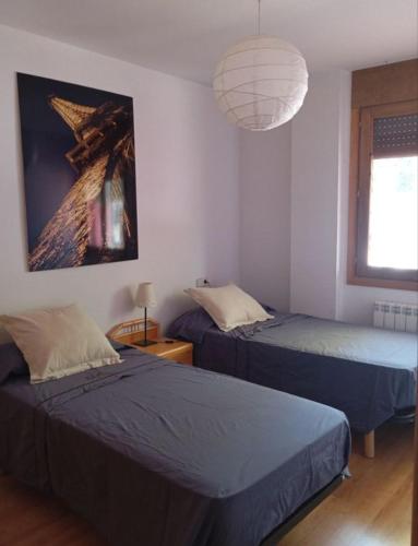a bedroom with two beds and a light fixture at Pis Relapieso in Vilaller