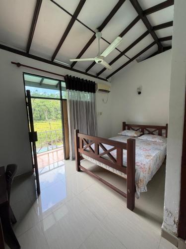 a bedroom with a bed and a large window at Nuwanma in Halpatota