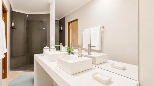 a white bathroom with three sinks and a shower at Ark de Triomphe in Riebeek-Wes