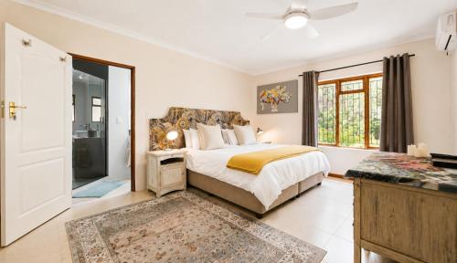 a bedroom with a bed and a large window at Ark de Triomphe in Riebeek-Wes