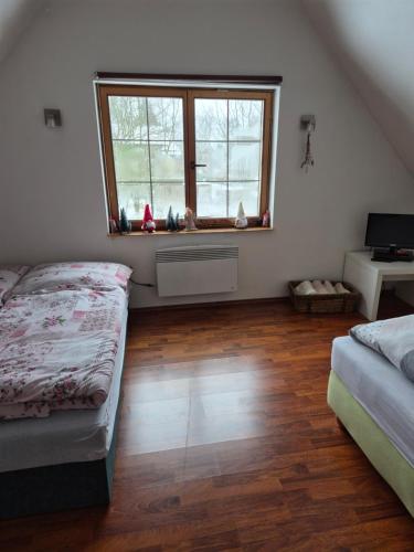 a bedroom with two beds and a window at Roubenka Krkonoše - Adršpach in Radvanice