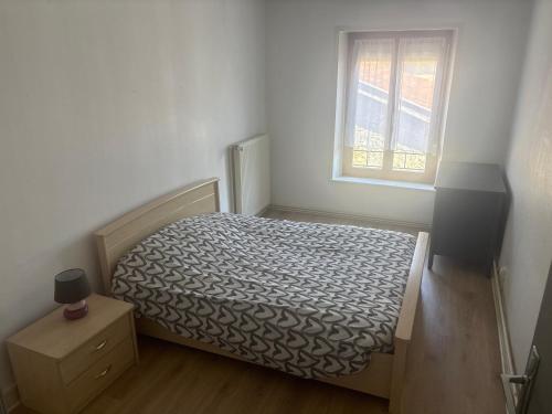 a small bedroom with a bed and a window at Belle appartement in Saint-Mihiel