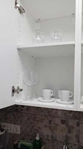 a kitchen counter with cups and plates on a shelf at Alteagroup Joy in Altea
