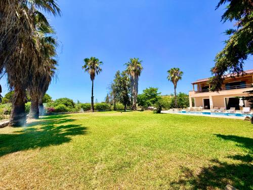 a large yard with palm trees and a house at Palm Villa Ammes in Svoronata