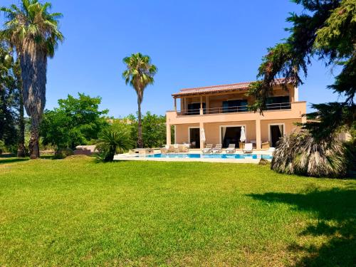 a house with a pool and palm trees at Palm Villa Ammes in Svoronata