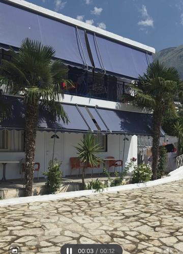 a building with palm trees in front of it at Vila Hana in Dhërmi