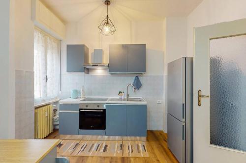 a kitchen with blue cabinets and a stainless steel refrigerator at [DolciAcque] Dolce sosta nel cuore di Acqui in Acqui Terme
