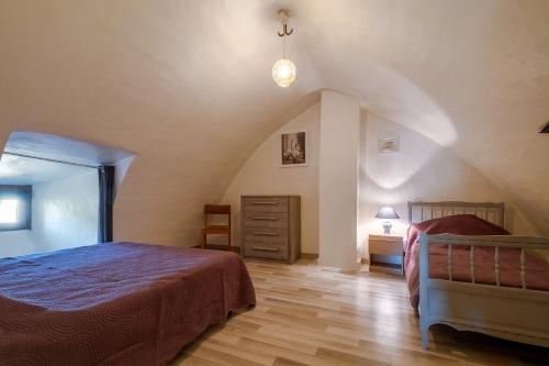 a bedroom with a bed and a dresser in a attic at Gîte l'anémone 6/7 personnes in Saint-Pierre-des-Tripiers