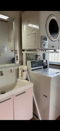 a kitchen with white cabinets and a sink at Guest house En in Fujiyoshida