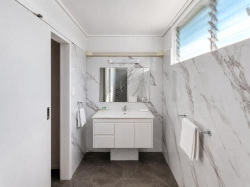 a white bathroom with a sink and a mirror at Gladstone CBD Motel in Gladstone