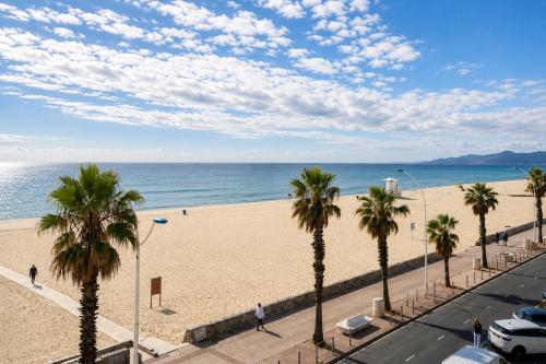a view of a beach with palm trees and the ocean at ROSEVA - T2 Vue mer - Plage à pied - Balcon - Climatisation in Canet-en-Roussillon