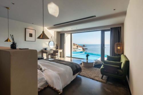 a bedroom with a large bed and a view of the ocean at XIHUI Cliff Hotel in Tian'ao