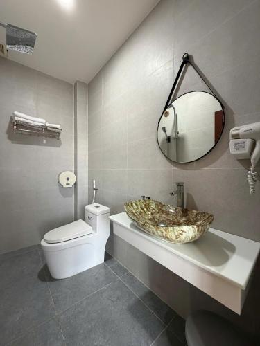 a bathroom with a sink and a toilet and a mirror at AOC HOTEL in Cao Lãnh