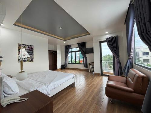 a bedroom with a bed and a couch and windows at AOC HOTEL in Cao Lãnh