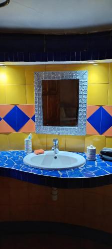a bathroom with a sink and a mirror at Villa Les Flamboyants in Somone