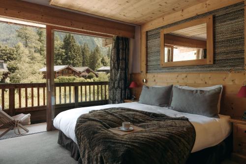 a bedroom with a bed and a large window at Les Grands Montets Hotel & Spa in Chamonix