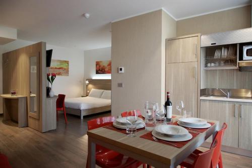 Una habitación con mesa de comedor y un dormitorio. en Privilege Apartments, en Vimercate