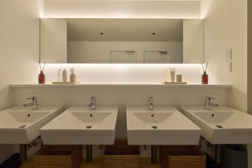 a bathroom with four sinks and a large mirror at AO Odawara Lounge in Odawara