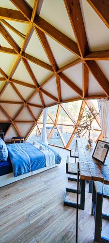 a bedroom in a tent with a bed and a table at Dôme Bao SPA luxe climatisé in Lesterps