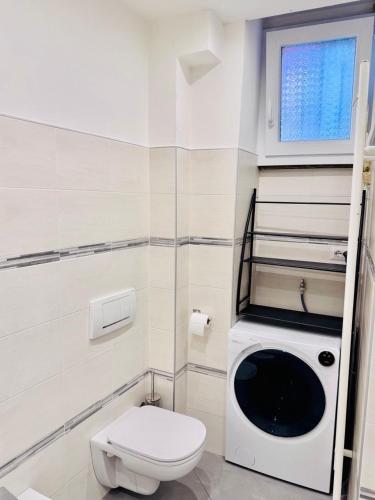 a white bathroom with a toilet and a window at Nice apartment in the historic center in Verbania