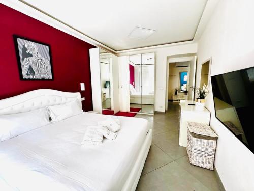a bedroom with a white bed and a red wall at Nice apartment in the historic center in Verbania