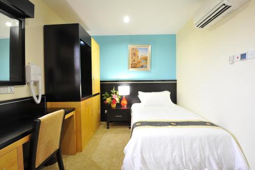 a hotel room with a bed and a flat screen tv at Hallmark View Hotel in Melaka
