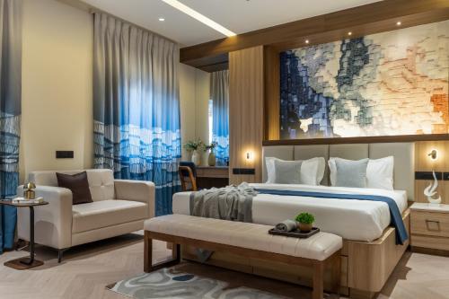 a bedroom with a large bed and a chair at Hotel Serenity Suites in Nagpur