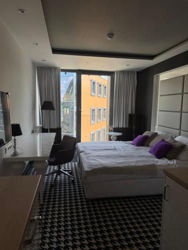 a hotel room with a bed and a desk and a window at Apartament Piano 21 in Opole