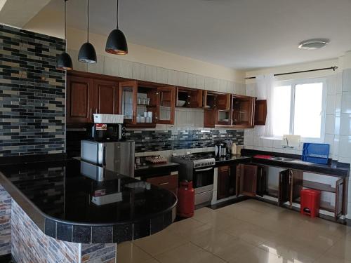 a kitchen with wooden cabinets and a black counter top at Emirates in Mombasa