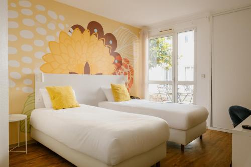 two beds in a room with a flower mural on the wall at Green Hôtels Bordeaux Arena in Latresne