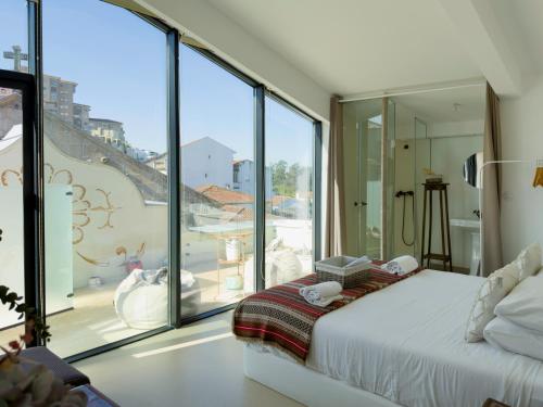 a bedroom with a bed and a large window at Casa Matriz Séc. XVI | Double or Twin w/ balcony in Penafiel
