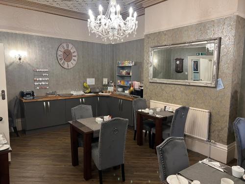 a dining room with tables and chairs and a chandelier at Fox lodge in Blackpool