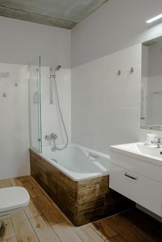 a bathroom with a shower and a tub and a sink at Apartamenty 107 in Rumia