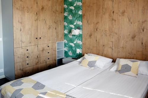 a bedroom with a large bed with two pillows at Apartamenty 107 in Rumia