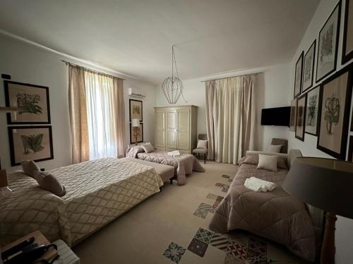 a bedroom with two beds and a living room at Casina Metrano - Castello Monaci in San Pancrazio Salentino