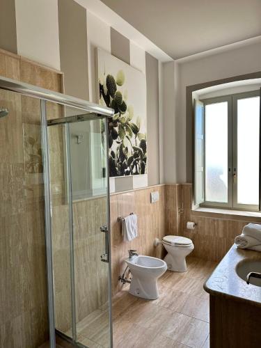 a bathroom with a toilet and a glass shower at Casina Metrano - Castello Monaci in San Pancrazio Salentino