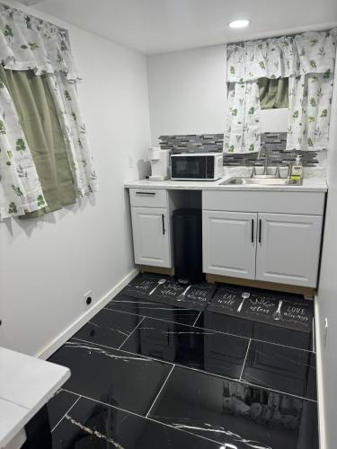 a small kitchen with a sink and a microwave at Cozy Broadway in Minneapolis