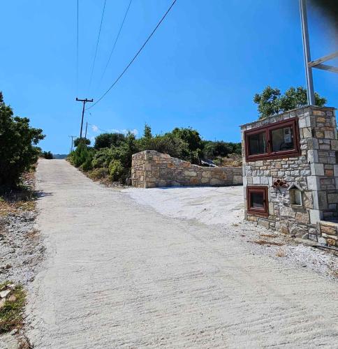 an empty road with a stone building on the side at Alyki Stone House 4 in Alyki