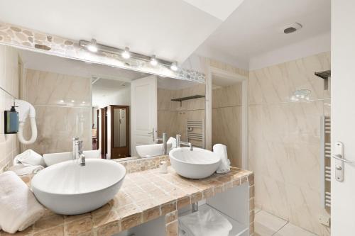 a bathroom with two sinks and a large mirror at Le Beau Séjour in Saint-Raphaël