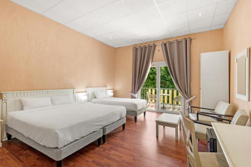 a hotel room with two beds and a balcony at Le Beau Séjour in Saint-Raphaël