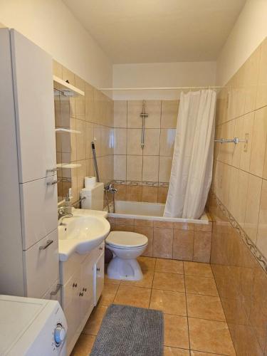 a bathroom with a toilet and a tub and a sink at Apartment and room Gušćić in Rab